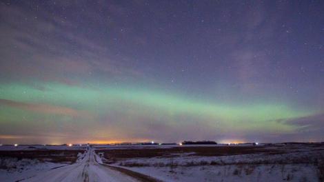 The northern lights, or aurora borealis, illuminate the winter night sky