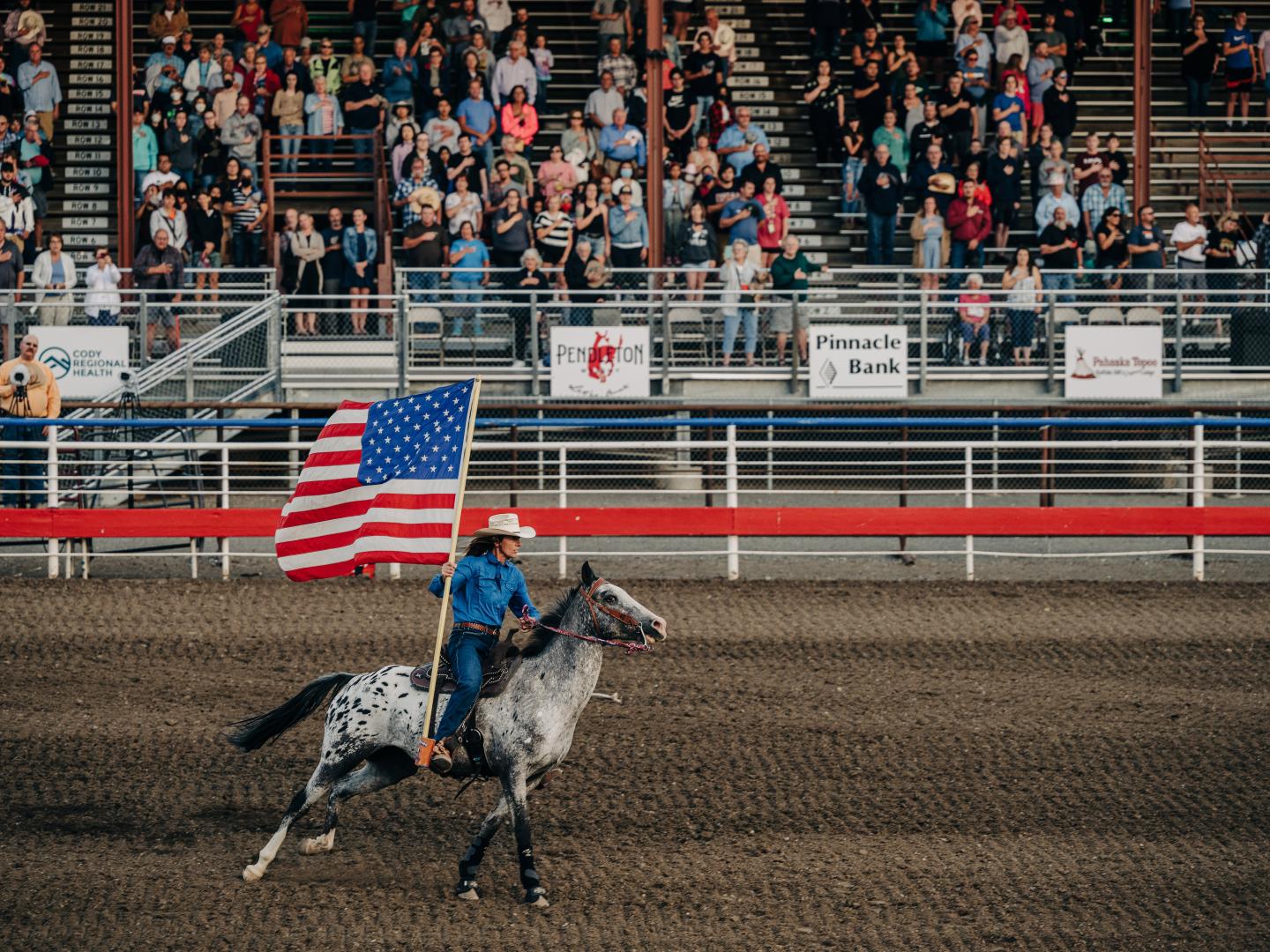 Cavalier portant le drapeau américain lors du Cody Stampede Rodeo dans le Wyoming