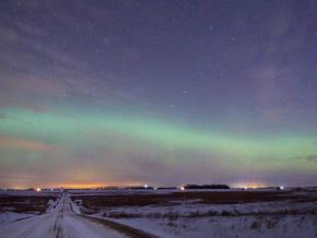 The northern lights, or aurora borealis, illuminate the winter night sky
