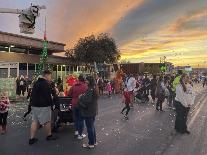 アリゾナ州キングマンのダウンタウンで開催されるベリー・メリー・ストリート・オブ・ライツで、クリスマスのイルミネーションや人工雪を鑑賞する来場者