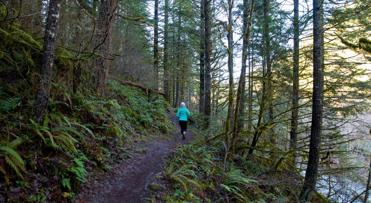 Running along a lush, woodsy trail in Oregon