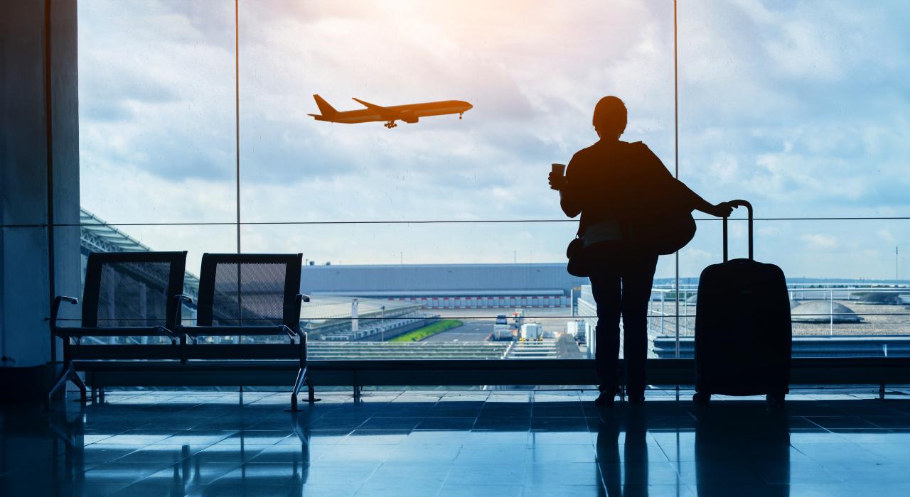 Woman watching plane take off at airport