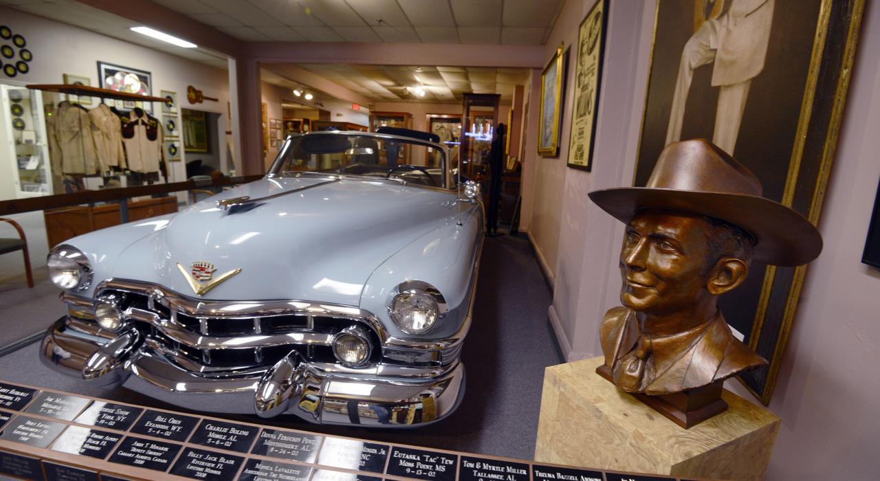 A bust of the Country musician and his blue Cadillac at the Hank Williams Museum